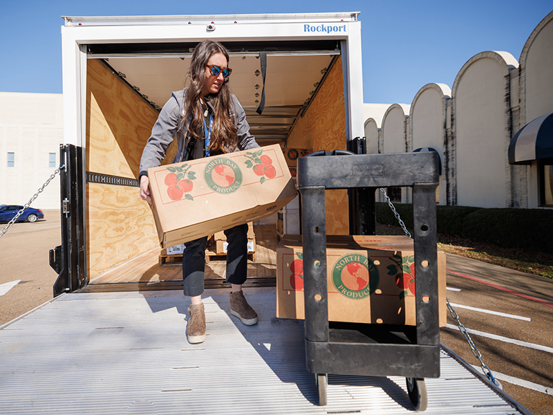 Rebecca Butz, an instructor in the UMMC School of Population Health, unloads boxes of food from the Mississippi Food Network at the EversCare Clinic at the Jackson Medical Mall.